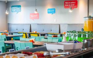 a restaurant with tables and chairs and signs on the wall at ibis Styles Sao Mateus in São Mateus