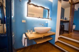 un bagno con lavandino e specchio su una parete blu di Villa Mandrioli a Cecina