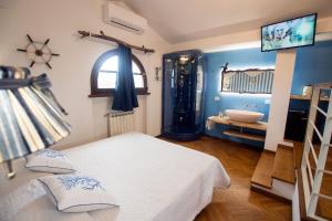 a bedroom with a bed and a bathroom with a sink at Villa Mandrioli in Cecina