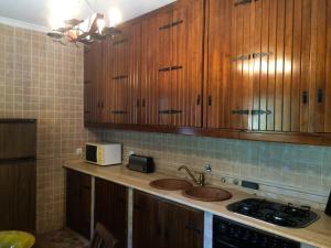 a kitchen with wooden cabinets and a sink at Quinta de Catapeixe Douro River in Magrelos