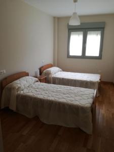 a room with two beds and a window at Apartamento Costa de Lugo in Foro