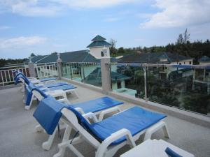eine Reihe von blauen und weißen Stühlen auf einem Balkon in der Unterkunft White Cat Hotel in Khao Lak