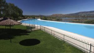 a large swimming pool with a fence around it at Las Encarnas in Braojos de la Sierra
