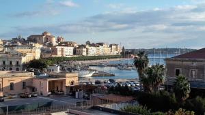 een stad met een haven met boten in het water bij Eleven in Siracusa