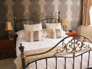 Schlafzimmer mit einem Bett mit weißer Bettwäsche und Kissen in der Unterkunft Autumn Leaves Guest House in Whitby