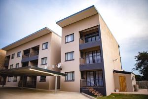 an apartment building with a parking lot at The Living Collective Apartments in Pietermaritzburg