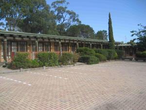 a building with a brick courtyard in front of it at Mahogany Park in Cranbourne