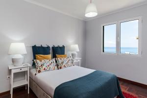 una camera bianca con un letto e una finestra di Piornais I by An Island Apart a Funchal