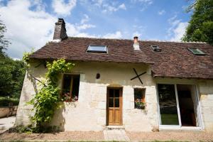 ein kleines Haus mit einer Frau auf dem Dach in der Unterkunft Holiday home Le Vaugarnier in Couture-sur-Loir