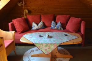 a red couch with pillows on top of a table at Haus Schimmelreiter in Greetsiel
