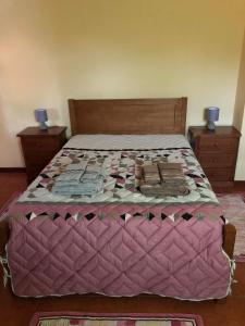 a bed with a pink quilt and two night stands at Douro vineyards and Mountains in Urgueira
