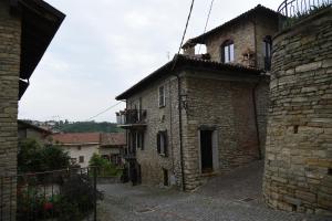 - un ancien bâtiment en briques avec un balcon au-dessus dans l'établissement Il borgo, à Montabone