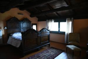 1 dormitorio con cama de madera y ventana en Il borgo, en Montabone