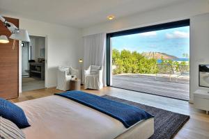 a bedroom with a large sliding glass door to a patio at Villa Eranos in Saint Barthelemy