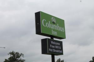 a green street sign on top of a pole at Columbus Inn in Columbus