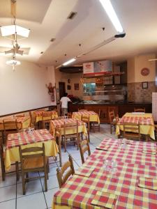 a restaurant with tables and chairs and a person in the kitchen at Affittacamere "Gilda INN Agerola" in Agerola