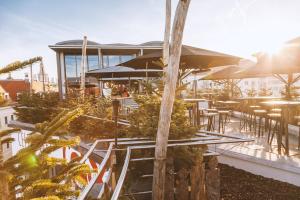 a restaurant with tables and umbrellas on a patio at Staycity Aparthotels Dresden City Centre in Dresden
