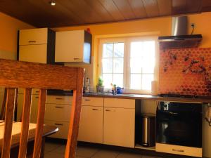 a kitchen with white cabinets and a stove top oven at FeWo Gutendorf in Bad Berka