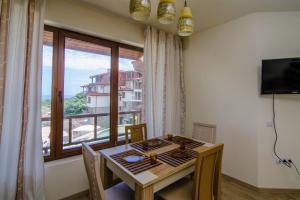 a dining room with a table and a large window at Apartment Balchik in Balchik