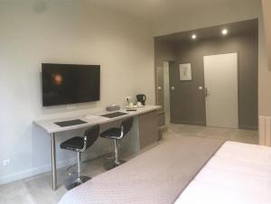 a bedroom with a desk with two chairs and a tv at Le Parc Stanislas in Chartres