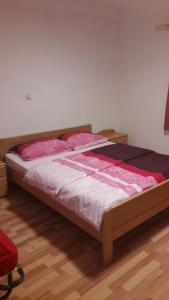 a bedroom with a bed with pink and white sheets at Apartment Matej in Senj