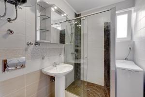 a white bathroom with a sink and a shower at Senada Apartments in Selce