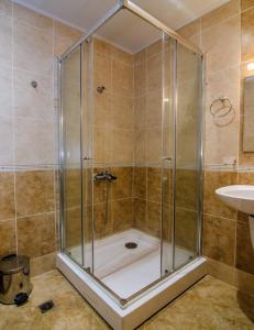 een douche met een glazen deur in een badkamer bij Apartment Balchik in Balchik