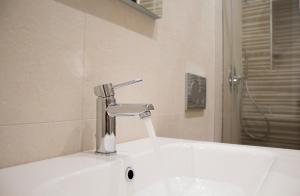 a white sink with a faucet in a bathroom at Cortile Osterio XIV in Cefalù +13 photos