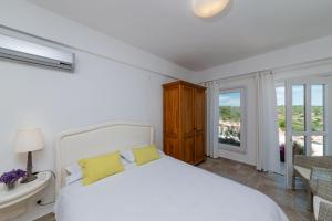 ボズジャ島にあるAika Akvaryumのベッドルーム(白いベッド、黄色い枕付)