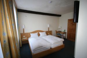 a bedroom with a bed with white sheets and pillows at Hotel Garni Lindenmühle in Bad Neuenahr-Ahrweiler +18 photos