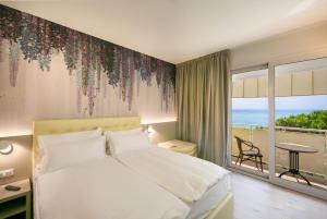 a bedroom with a bed and a view of the ocean at Hotel Le Lampare in Caorle