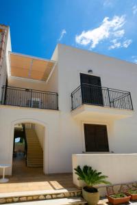 ein weißes Haus mit 2 Balkonen und einer Treppe in der Unterkunft Boa Vista San Vito - Area Fitness, Barbecue Area, Tennis Court in San Vito lo Capo