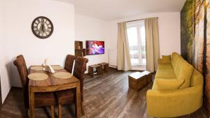 a living room with a table and a yellow couch at Rooftop apartment I. in Košice