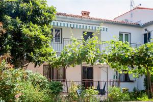 a white house with trees in front of it at Apartment and Studio Tereza in Rovinj