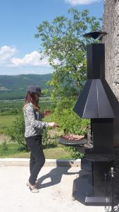 a woman is cooking food on a grill at Apartment Bataja in Brkač