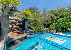 una piscina en un complejo con un tobogán de agua en Hotel Le Priss, en Manuel Antonio