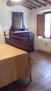ein Schlafzimmer mit einem Bett und einer Kommode in einem Zimmer in der Unterkunft Agriturismo San Pietro in Castiglione dʼOrcia