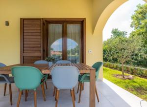 een eetkamer met een tafel en stoelen en een groot raam bij Villa Carmela in Labin