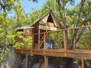 a tree house on a rock in the forest at Cabanes Lodges Le Servière in Balazuc