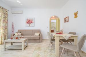 a living room with a couch and a table at Kapris House in Agios Prokopios