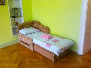 リヴィウにあるApartments on Valova 25の緑の壁の客室の小さなベッド1台分です。