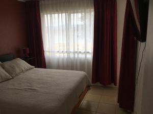 una camera da letto con un letto e una finestra con tende rosse di Bahía Pelícanos a Horcón Altre 51 foto