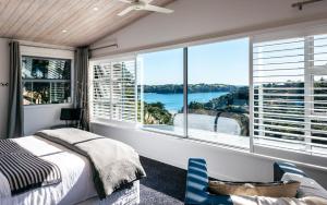 a bedroom with a bed and a large window at Wild Thyme in Oneroa