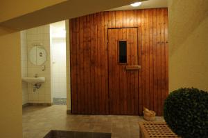 a wooden door in a bathroom with a sink at Asgard Hotel in Worms