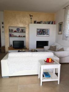 a living room with a large white bed and a couch at Oliveta in Tavarnelle Val di Pesa