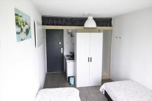 a bedroom with two beds and a white closet at Tiny Cottage op Camping "De stal" in Drijber