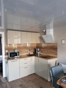 a kitchen with white cabinets and a microwave at Riverloft I in Cuxhaven +30 photos