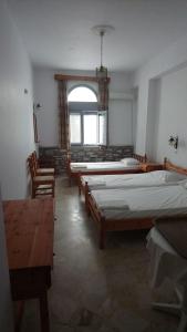 a room with three beds and a window at Kallirroi Studios in Pythagoreio