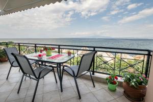 a table and chairs on a balcony with the ocean at Kallisti Apartment in Skala Kallirakhis