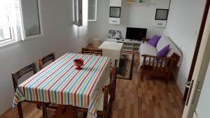 a room with a table and chairs and a living room at Apartman Vojaline in Milna